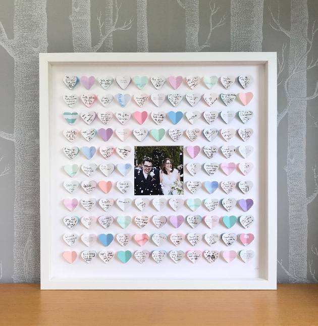 A white frame filled with colourful hearts and an image of a couple on their wedding day
