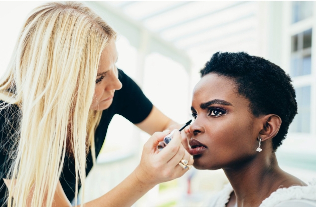 A woman applying another woman's make-up