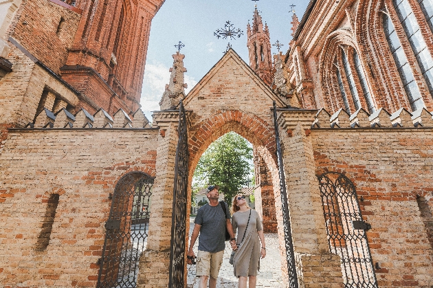 A man and woman walking underneath an arch