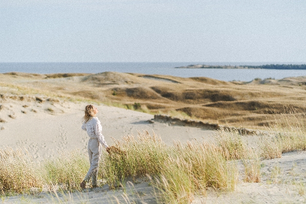 A woman on the beach looking out at the sea