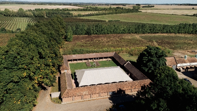 A birds eye view of a square building with a marquee in the centre