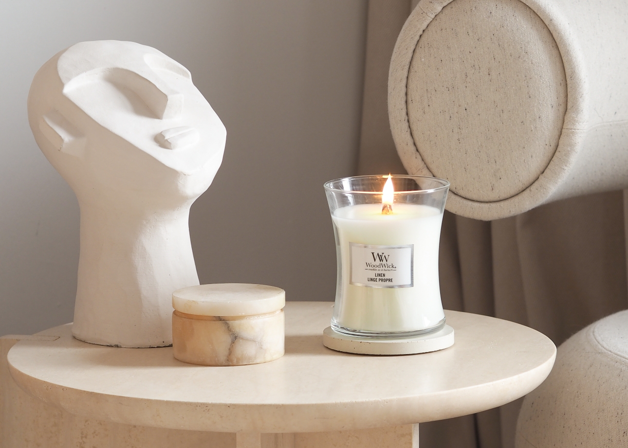 candle lit and on a table in a white colour