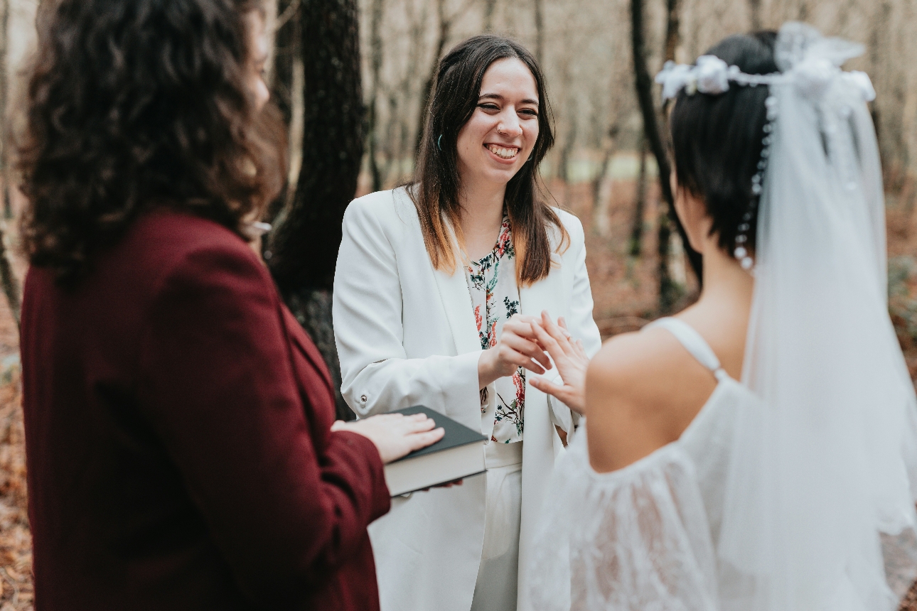 couple tying knot in woods with a celebrant