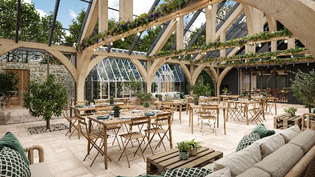 A large orangery decorated with greenery, tables and lights