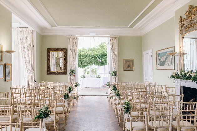 A light-filled room decorated with chairs and flowers