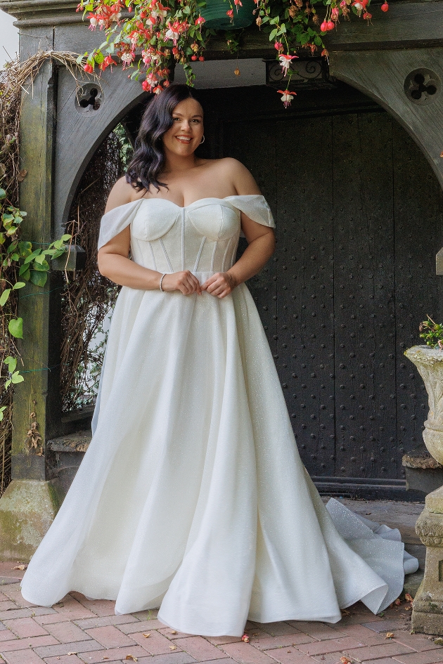 A woman smiling at the camera while wearing a wedding dress