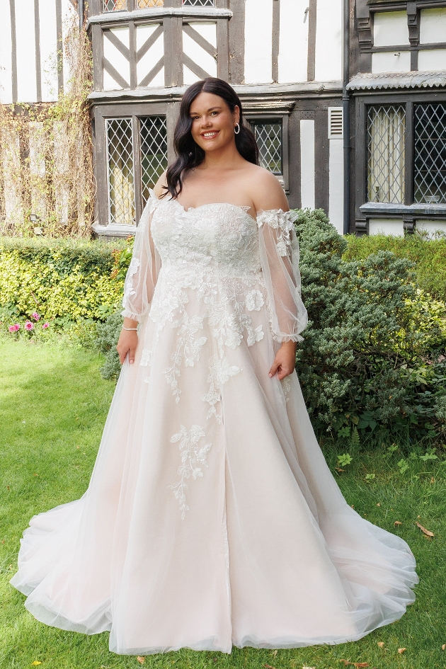 A woman smiling at the camera while wearing a wedding dress