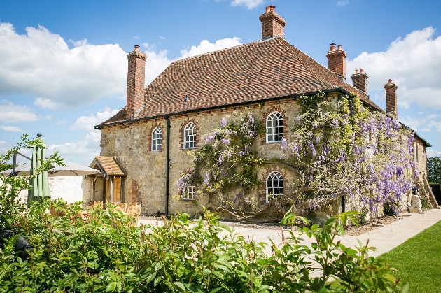 A stone building covered in ivy and lavender