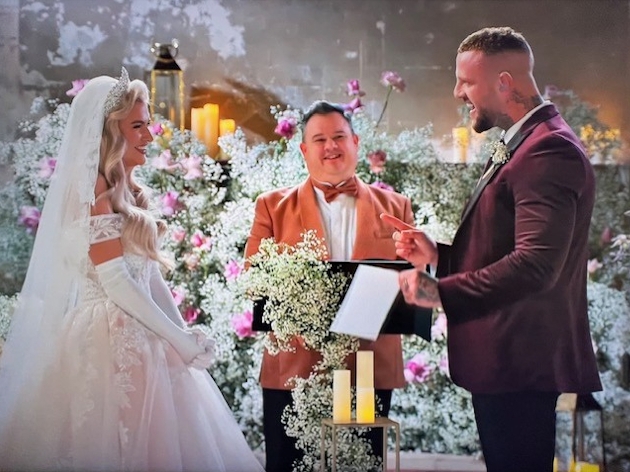 A man and woman getting married at the alter by a celebrant