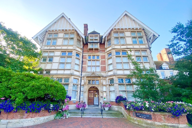 The exterior of a large white and brick building with lots of windows