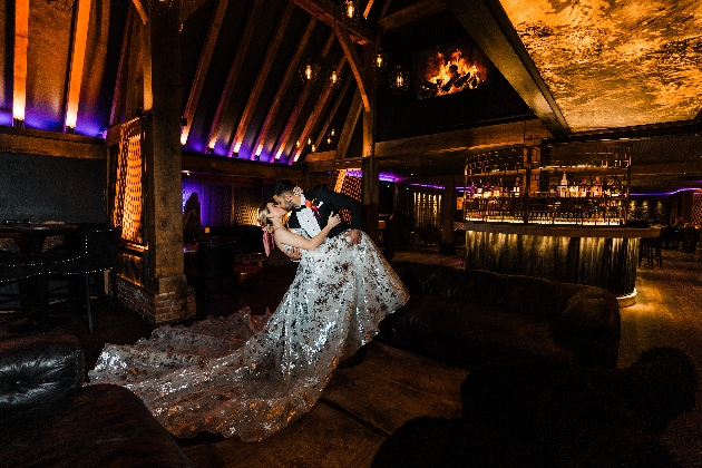 A bride and groom kissing in a dark room