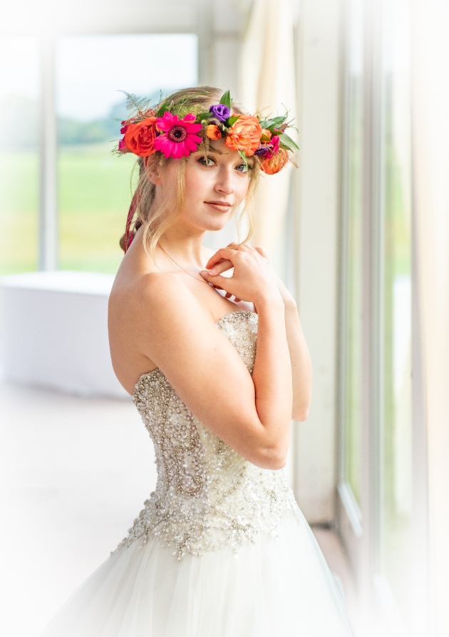 A bride looking at the camera while wearing a flower crown